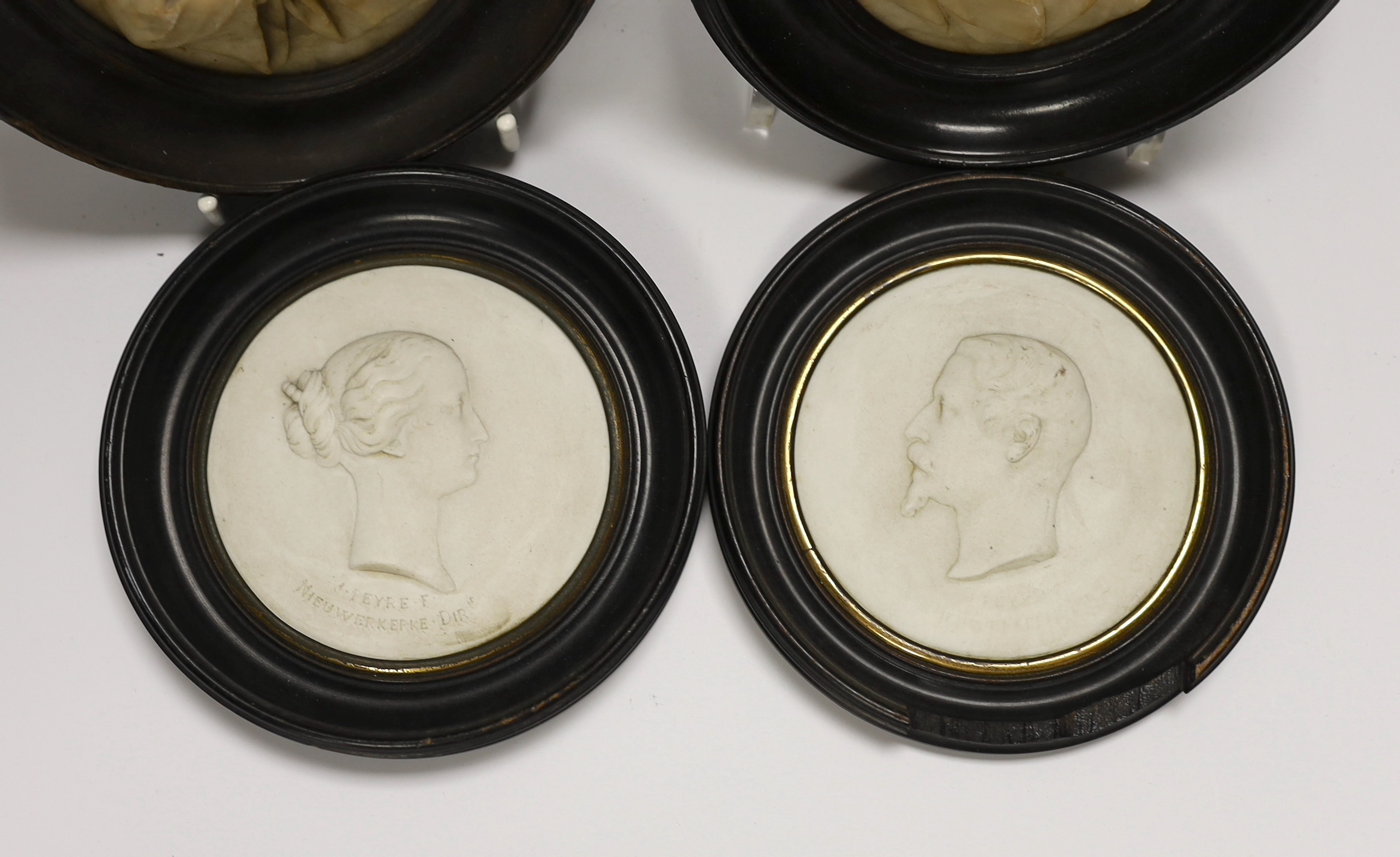 A pair of 19th century alabaster relief carved religious plaques and a pair of Sevres biscuit porcelain portrait plaques of Louis Napoleon and Eugene, housed in ebonized frames, largest overall 16cm high